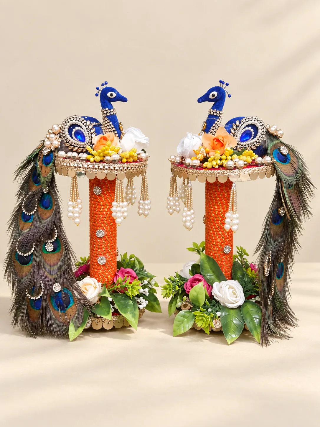Pair of handmade peacock stands with orange columns, flowers and pearl tassels